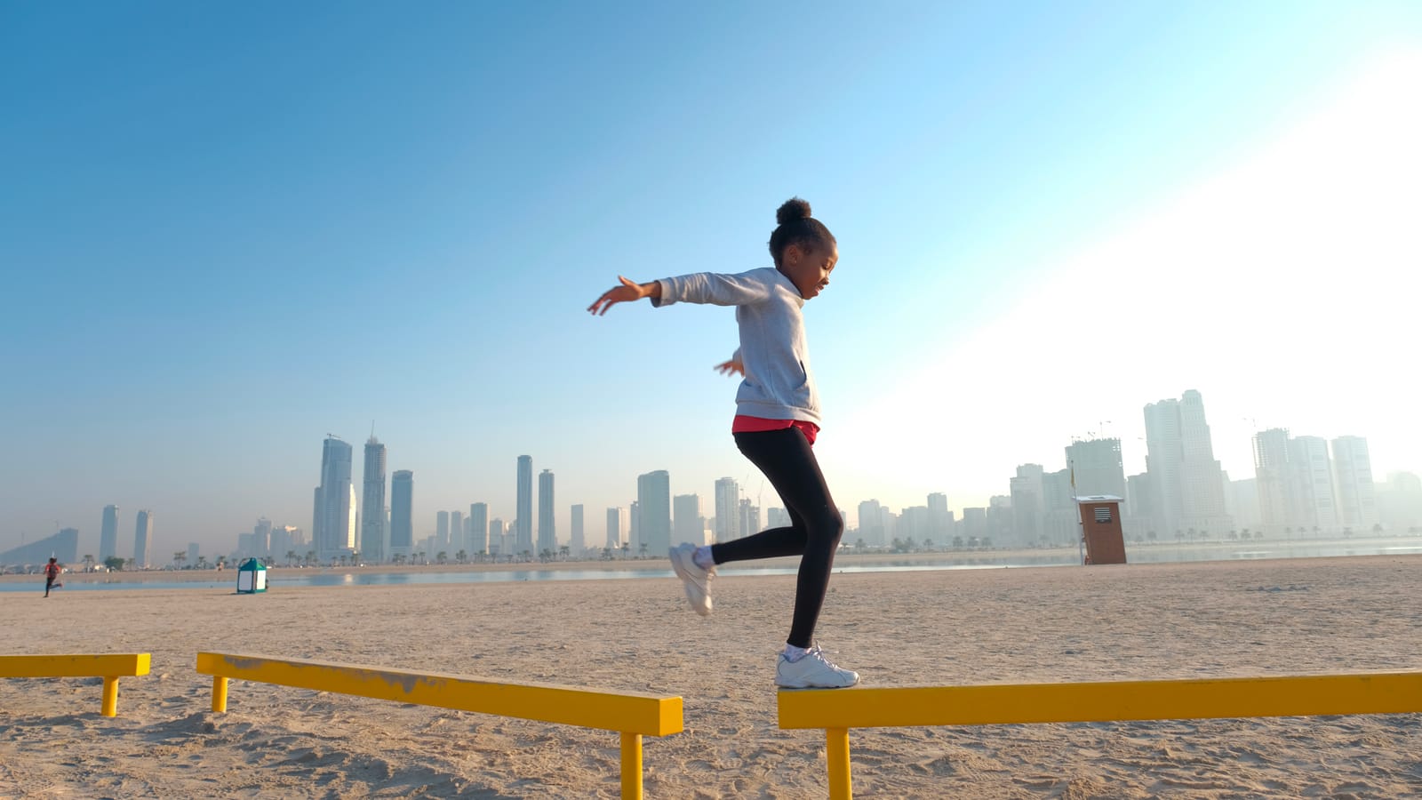 Girl balancing on beam at the beach