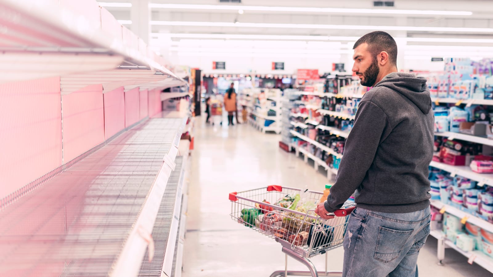 Customer looking at empty shelves Customer looking at empty shelves